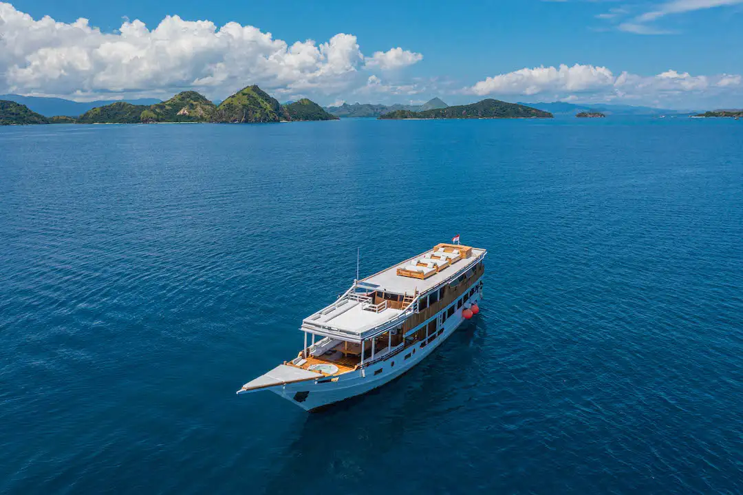 A liveaboard at anchor under a rising sun