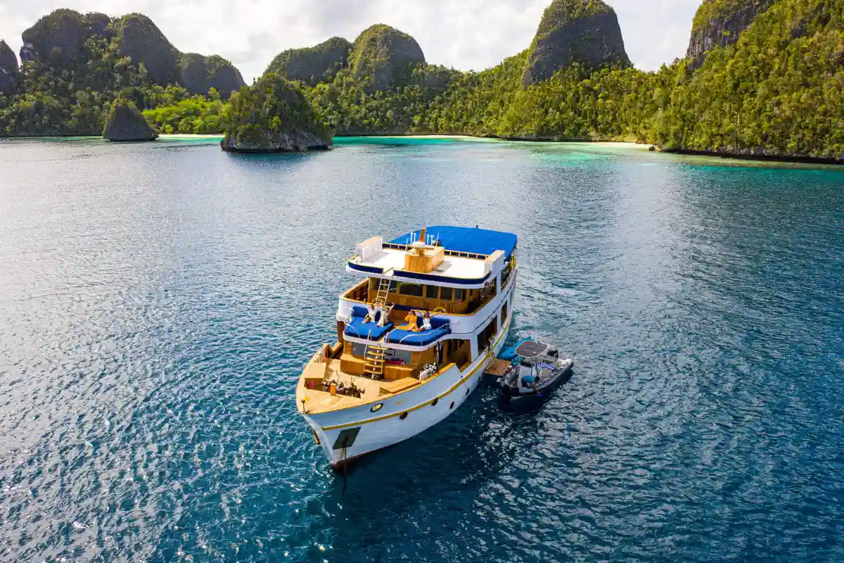 A phinisi motoring through open blue water